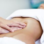 Hands massaging female abdomen.Therapist applying pressure on be