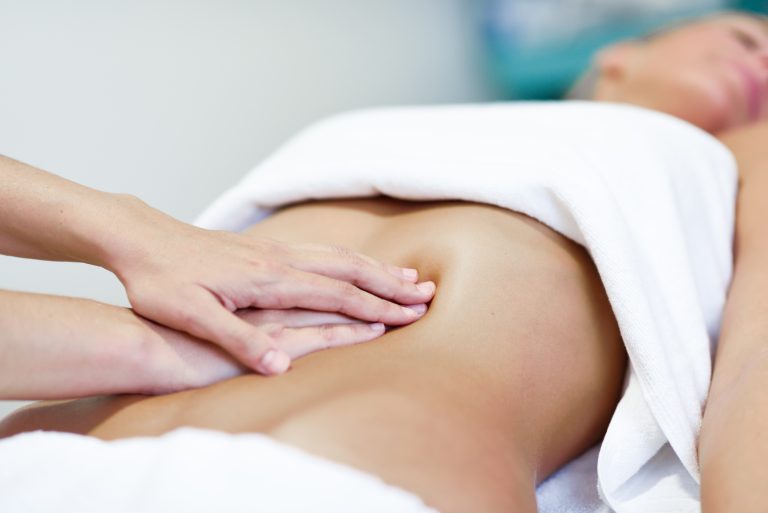Hands massaging female abdomen.Therapist applying pressure on be